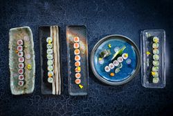 Set of various types of sushi on blue marble table