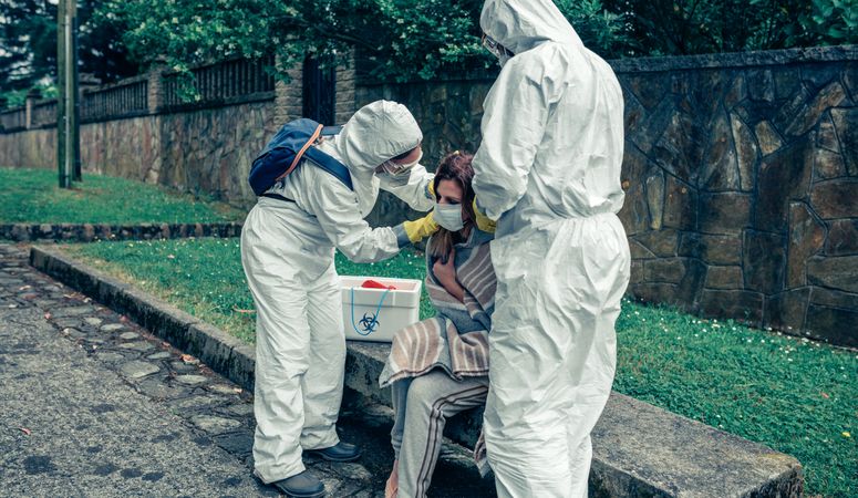 Doctors putting protective mask on woman infected with a virus