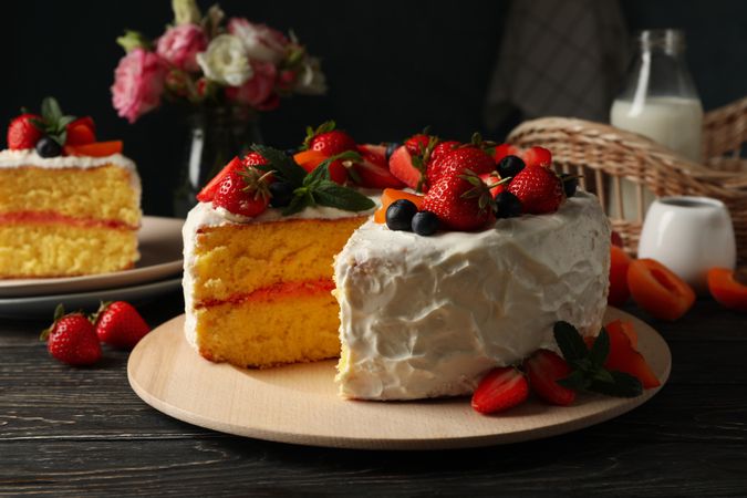 Composition with delicious berry cream cake on wooden table. Tasty dessert