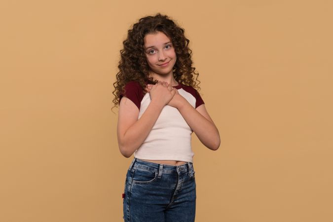 Young girl holding hands to chest, expressing gratitude