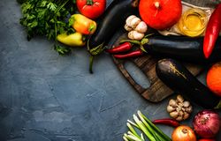 Eggplants and fresh vegetables on kitchen counter
