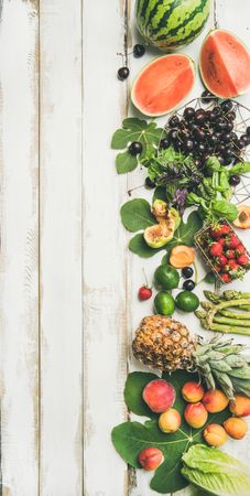 Summer fruits of watermelon halves, cherries, figs, strawberry on wood, with copy space