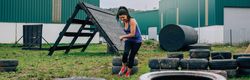 Participant in an obstacle course dragging wheels