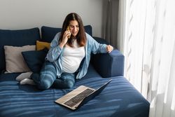 Pregnant woman talking on smartphone during remote work
