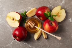 Top view of apples and honey on marble