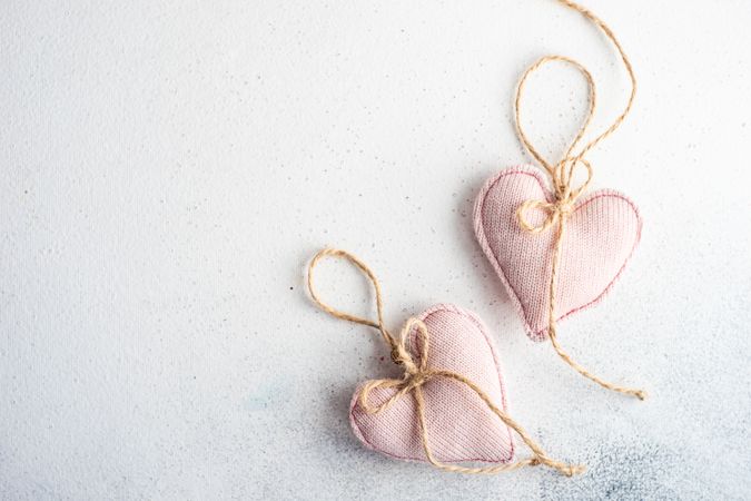 Valentine Day holiday card concept with felt pink heart decorations on marble counter