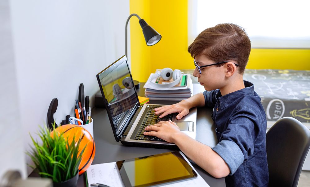 Boy doing homework with laptop