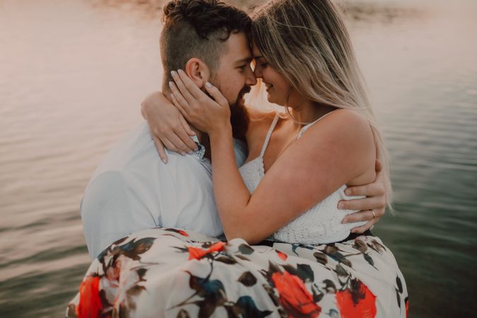 Loving couple standing ankle deep in water on beach
