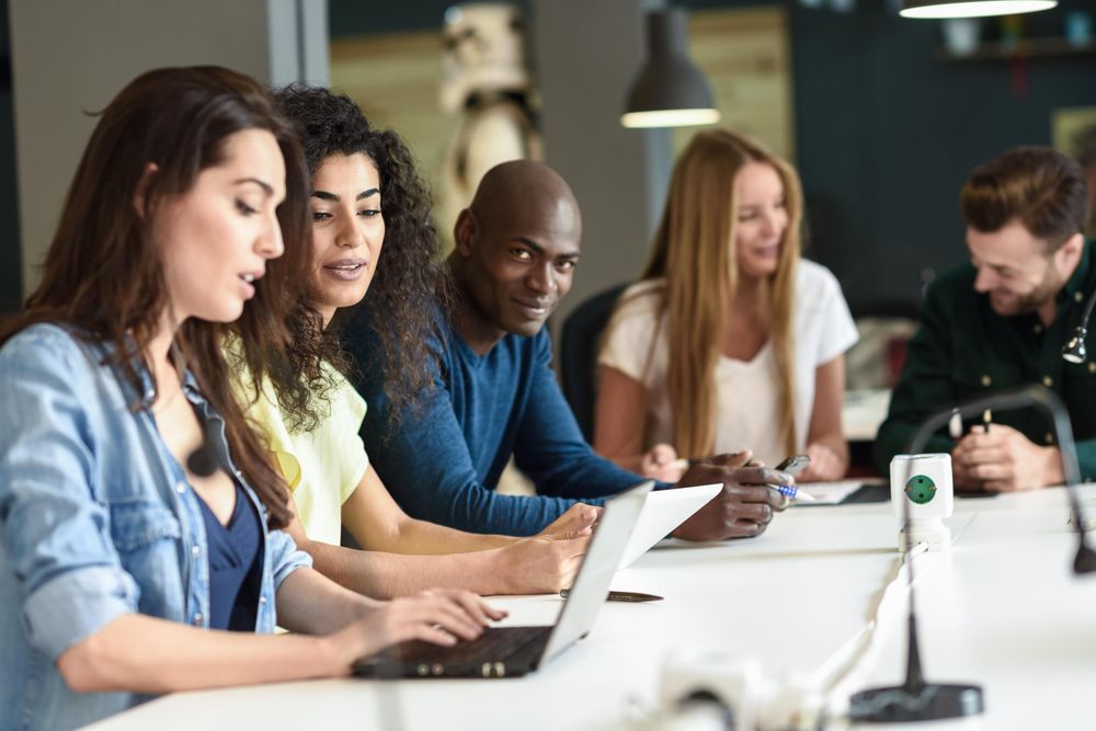 Five young people studying with laptop computer on desk