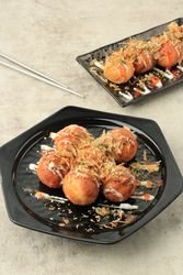 Takoyaki served with sauce and garnish, Japanese octopus dish