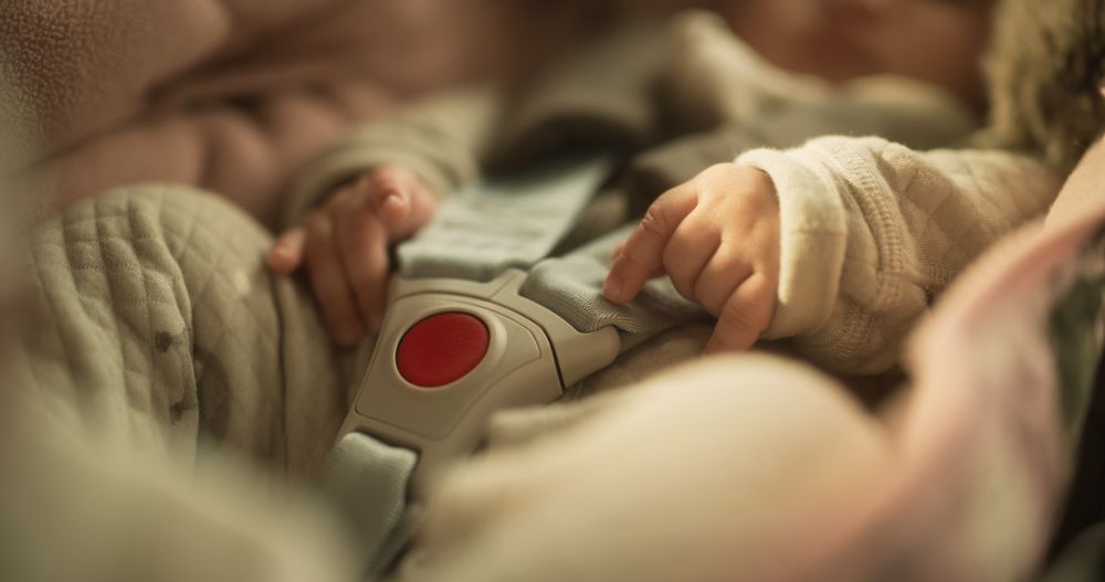 Shot of a Cute Asian Baby Sitting Calmly in a Car Seat with Safety Belt Securely Attached.
