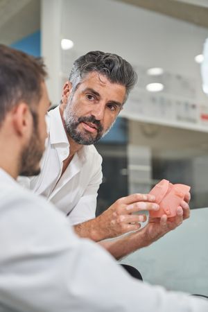 Man with respirator near colleague in office