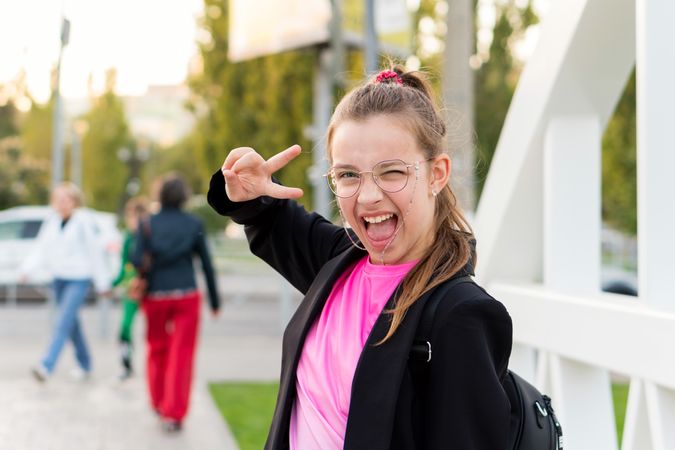 Girl giving peace sign while posing energetically