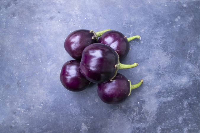 Fresh round eggplant on a grey concrete surface
