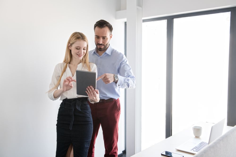 Man and woman working with tablet in team