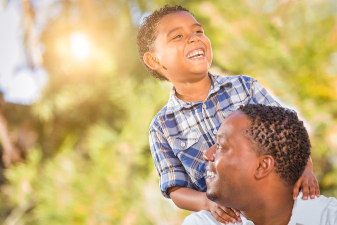 Son and Father Playing Outdoors Together On Beautiful Day