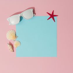 Beach accessories on pastel pink and blue background