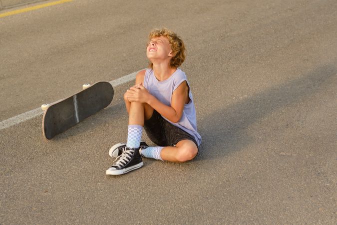 Skater suffering from pain after riding skateboard