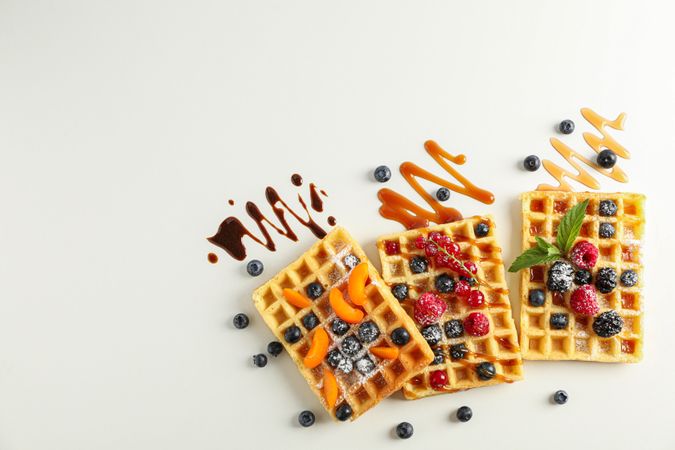Flat lay composition with waffles and different toppings, top view