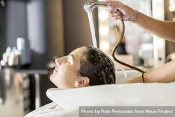 Relaxed female having her hair washed by stylist 43YnO0