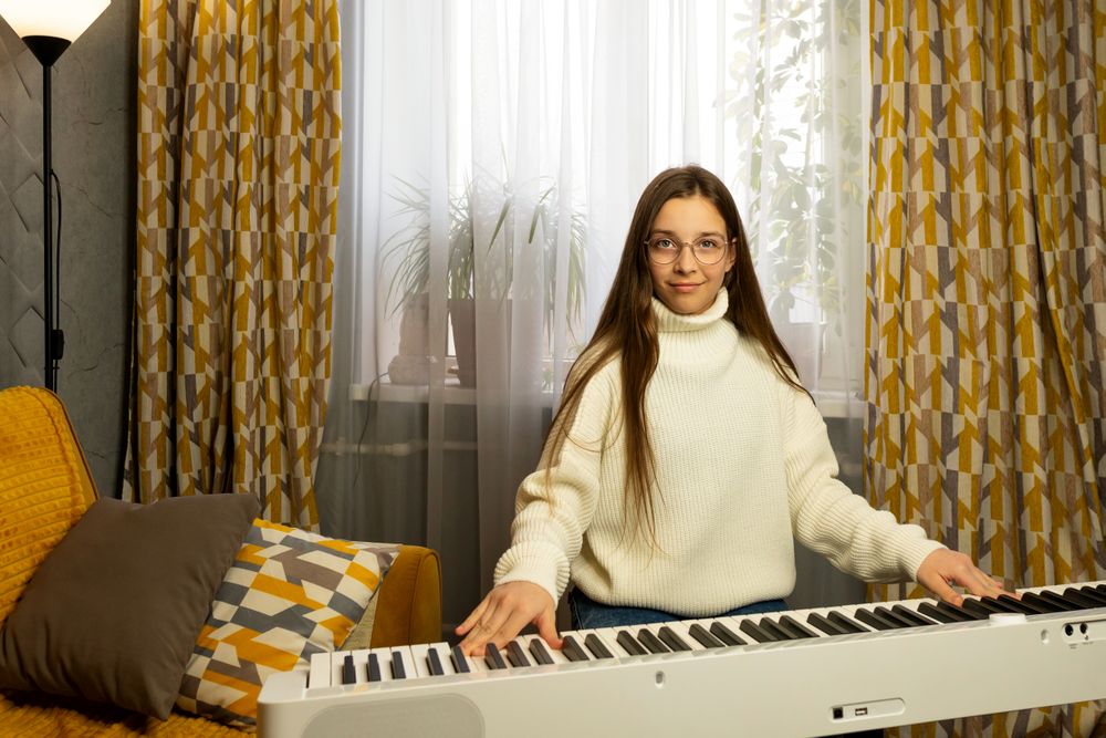 Girl with long hair playing the piano at home.