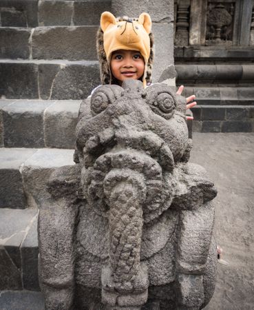 Java Island, Indonesia - August, 14 2015: Cute kid on aged statue