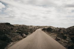 Cloudy sky over hill with road