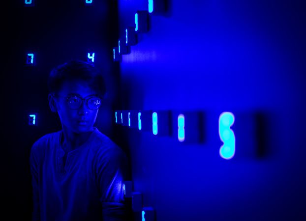 Man standing beside blue lit signage