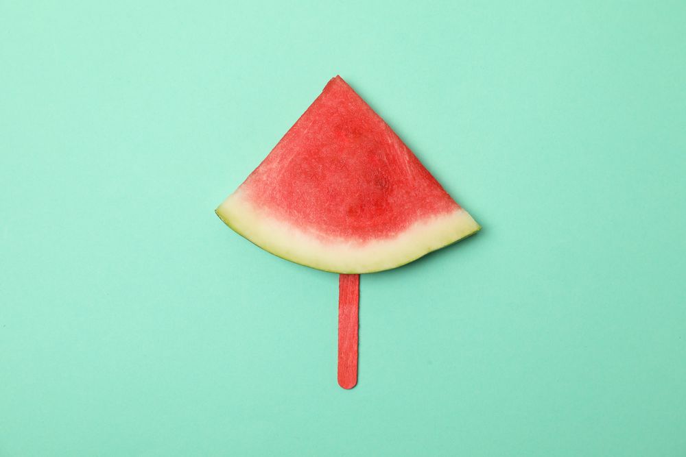 Watermelon slice on ice cream stick on mint background. Summer fruit