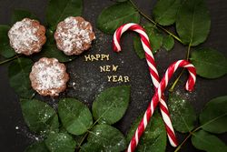 inscription of new year on a board with cupcakes and candy red