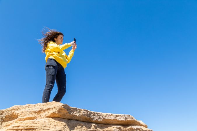 female taking photo of rocky landscape