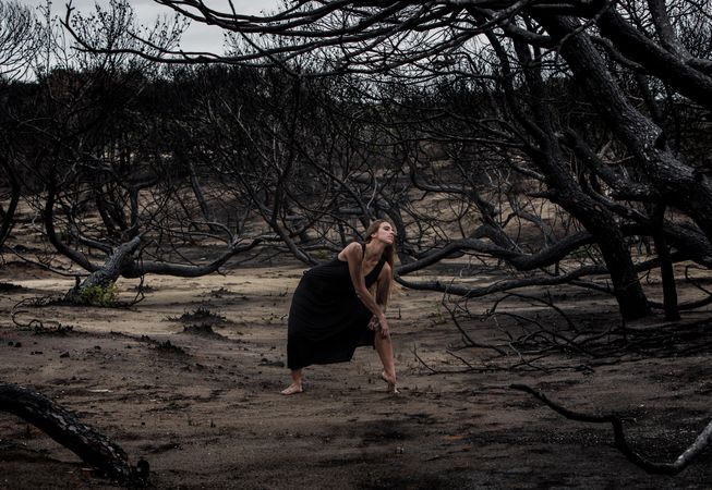 Woman dancing between dry trees