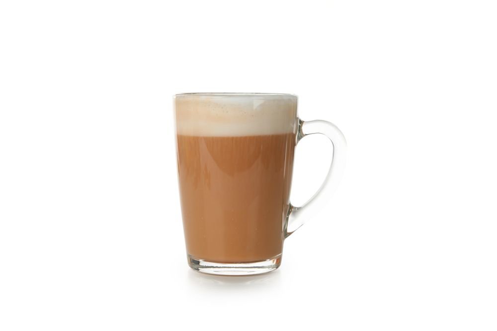 Glass cup of pumpkin latte isolated on neutral background
