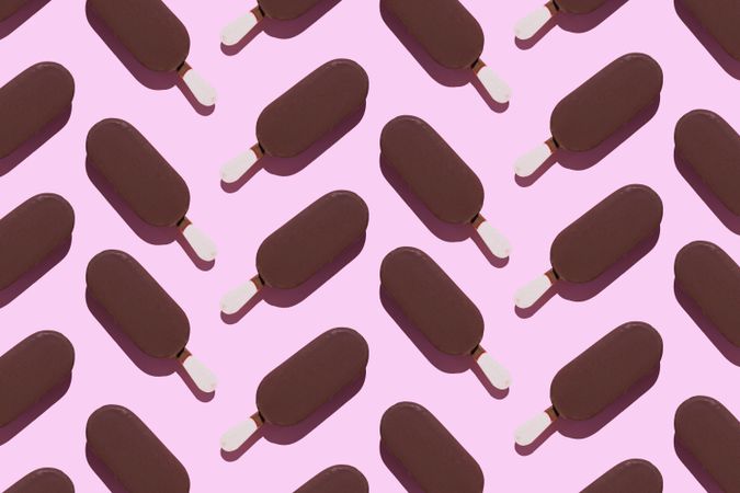 Chocolate popsicles on pink background in chevron pattern