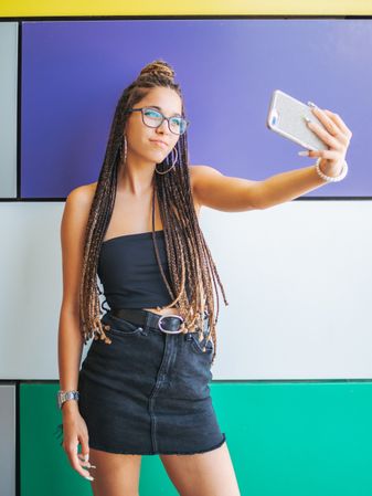 Woman with dreadlocks in glasses taking selfie