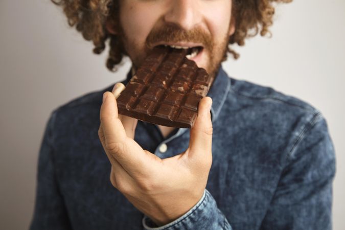 Close up of man eating chocolate bar