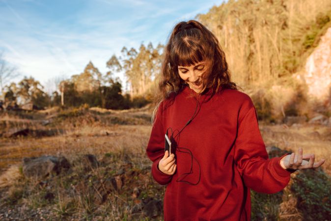 Young woman with smartphone dancing