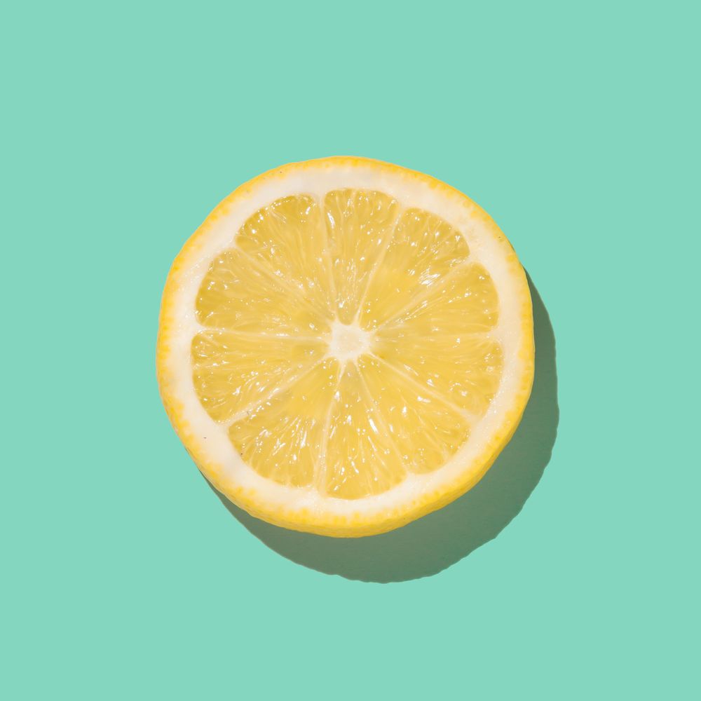 Fresh lemon slice close up on bright green background