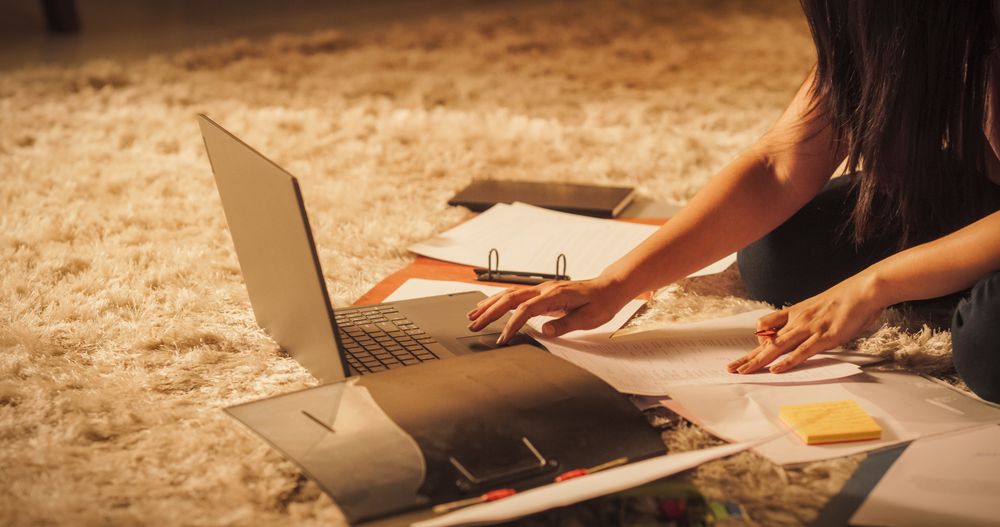 Close Up on Female Hands Using Laptop Computer and Papers in Sunny Cozy Apartment.