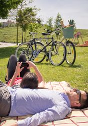 Woman using smartphone lying over man on the park
