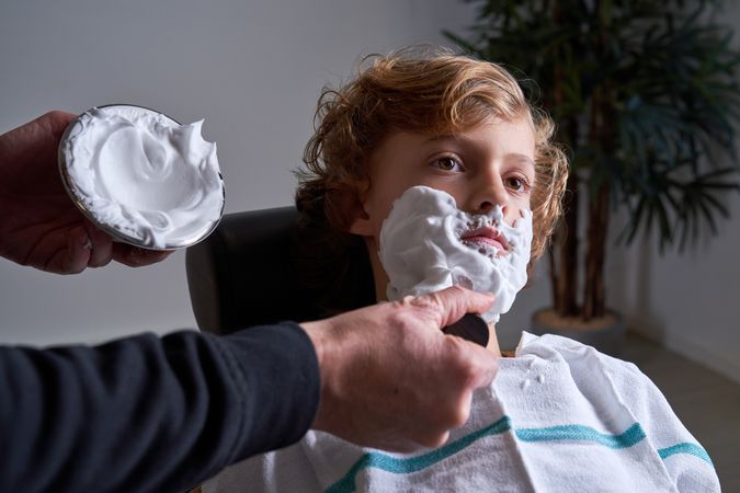 Boy shaving in a barbershop