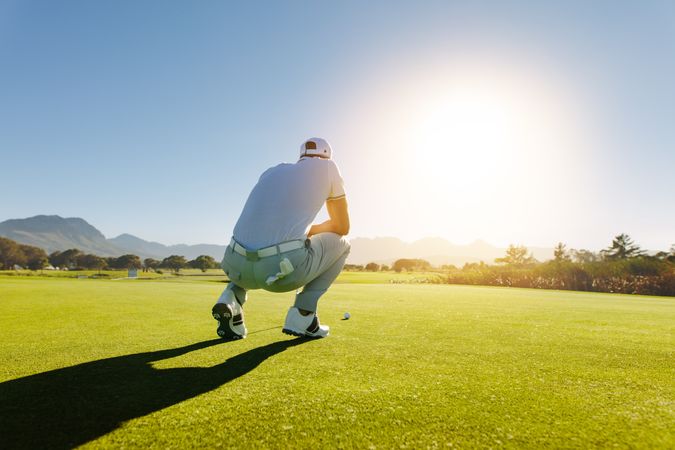 Skilled golfer analyzing golf ball on course