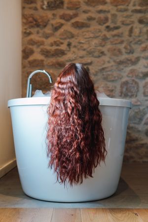 Anonymous woman taking bath at home