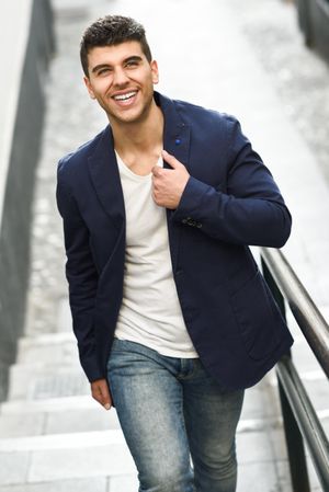 Smiling man in navy jacket walking up stairs
