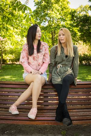 Multiethnic friends speaking on bench