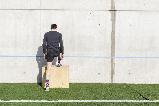 Man training on sports ground near wall
