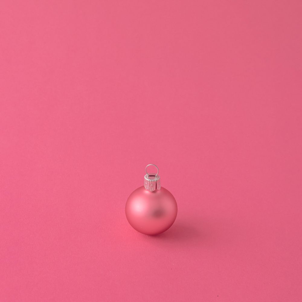 Pink Christmas bauble decoration on pink background