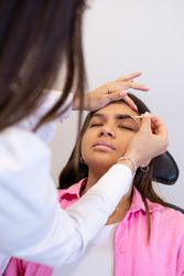 Beautician making eyebrow design and shading procedures