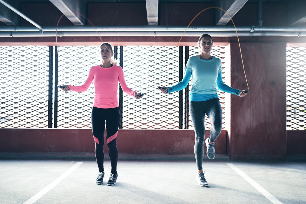 Two woman skipping rope near window