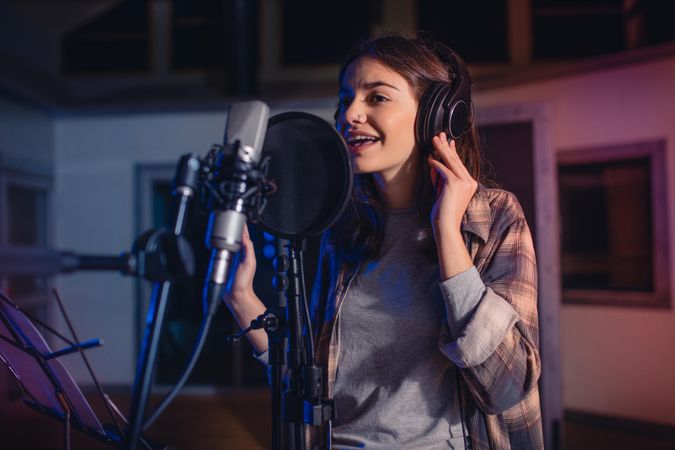 Woman singing a song in music recording studio